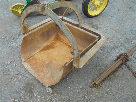 The trip handle looks like it can go on two ways, as if you could turn the bucket upside down ??? There are also 2 spring brackets underneath the back frame I"m wondering what they were for. . Ford 3pt dirt scoop